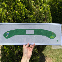 Load image into Gallery viewer, Hand holding a golf simulator screen with a golf course layout against a natural background needlepoint hanger