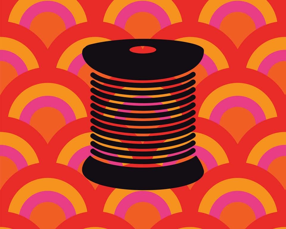 Black spool of thread on a colorful geometric pattern background